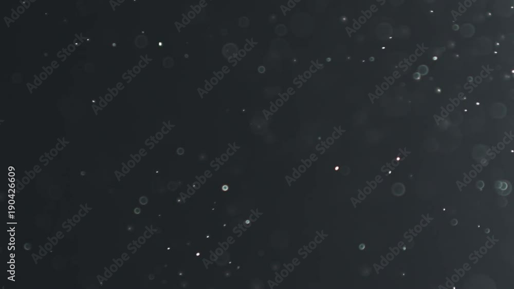 backlit dust particles with bubble like bokeh floating in slow motion backlit dust particles with bubble like bokeh floating in slow motion