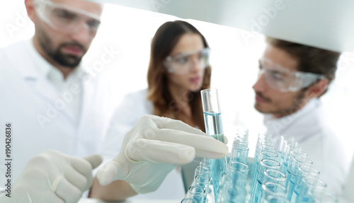 Fotografie background image is a group of scientists studying the liquid in the glass tube