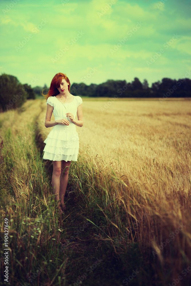 Beautiful redhead girl at meadow 