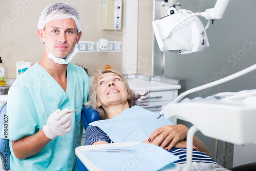 Dentist performing treatment to woman