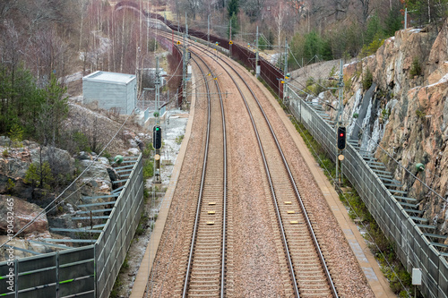 View from above of double railroad tracks in a mountain and forest evironment.