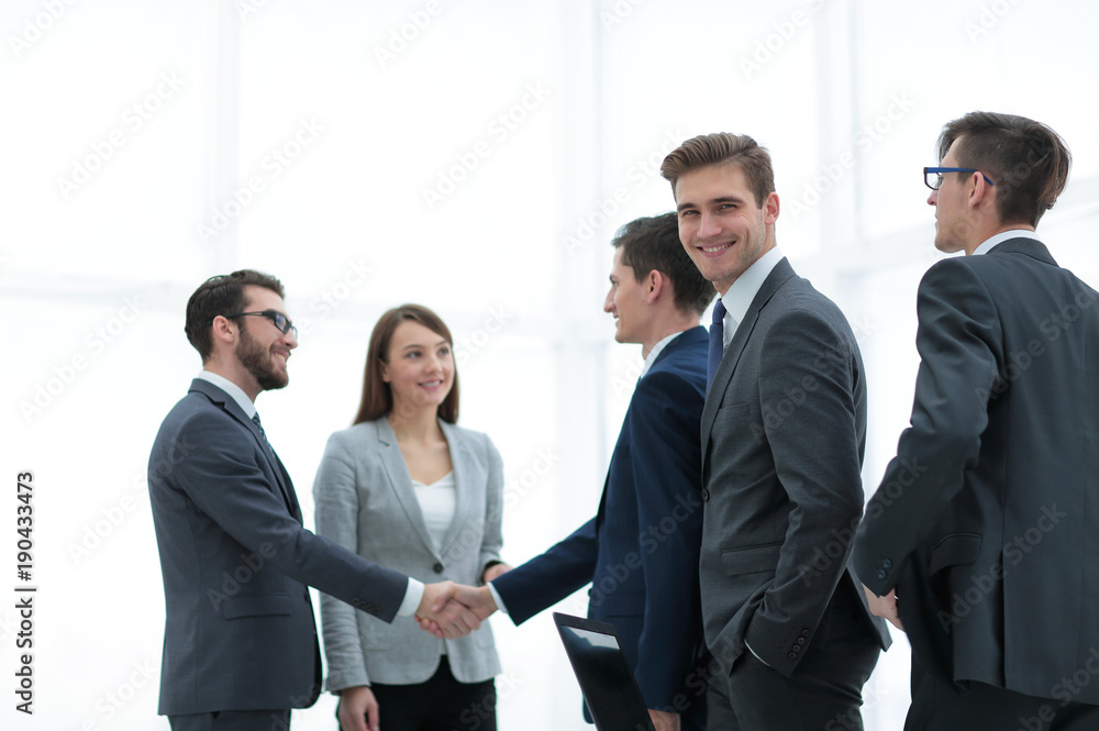 Business handshake. Two cheerful businessman shaking hands in o Business handshake. Two cheerful businessman shaking hands in o