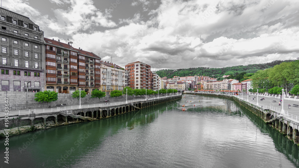 Classic houses and canoes in Nervion river in Bilbao