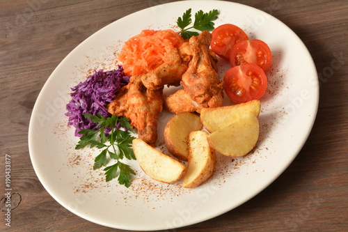 skrzydełka z kurczaka pieczone z ziemniakami, surówkami i pomidorem