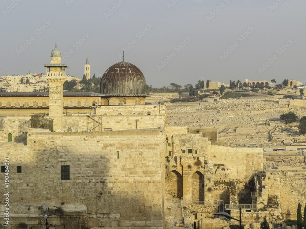 Jerusalem, Israel - view of  the Mosque. Jewish worshipers pray at the Wailing Wall, friday evening starting Shabbat in the sunset, Old City of Jerusalem.