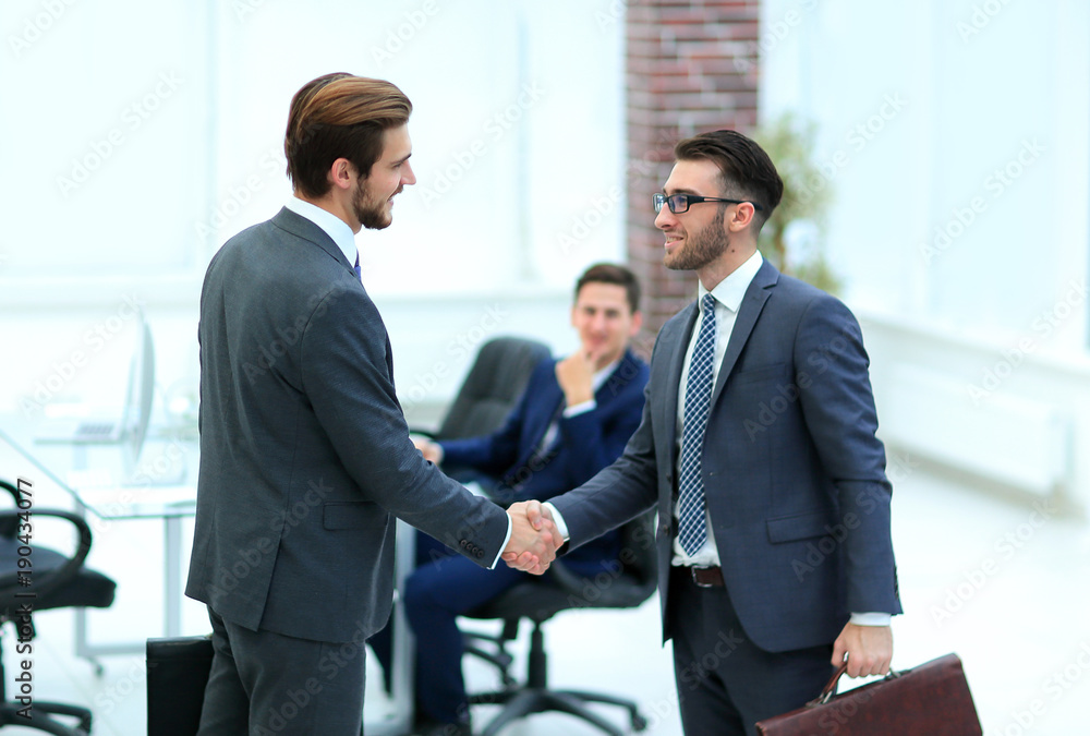 Two businessmen handshaking after striking grand deal Two businessmen handshaking after striking grand deal