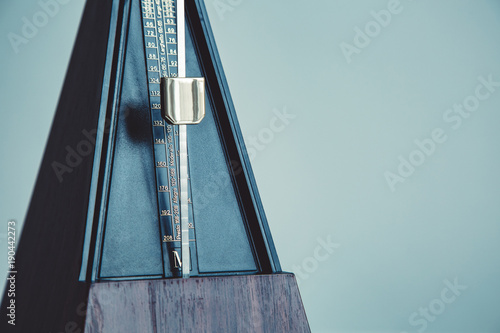 Φωτογραφία Color shot of a vintage metronome, on gray background.
