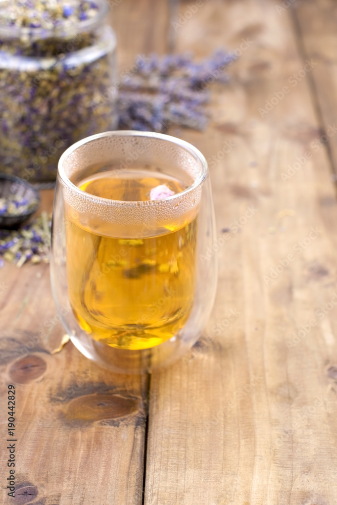 Herbal tea with lavender. In a glass with double walls. A bank of dried herbs for tea. Free space for text or a postcard. Herbal tea with lavender. In a glass with double walls. A bank of dried herbs for tea. Free space for text or a postcard.