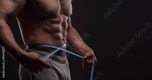 bodybuilder with a measuring tape around his waist