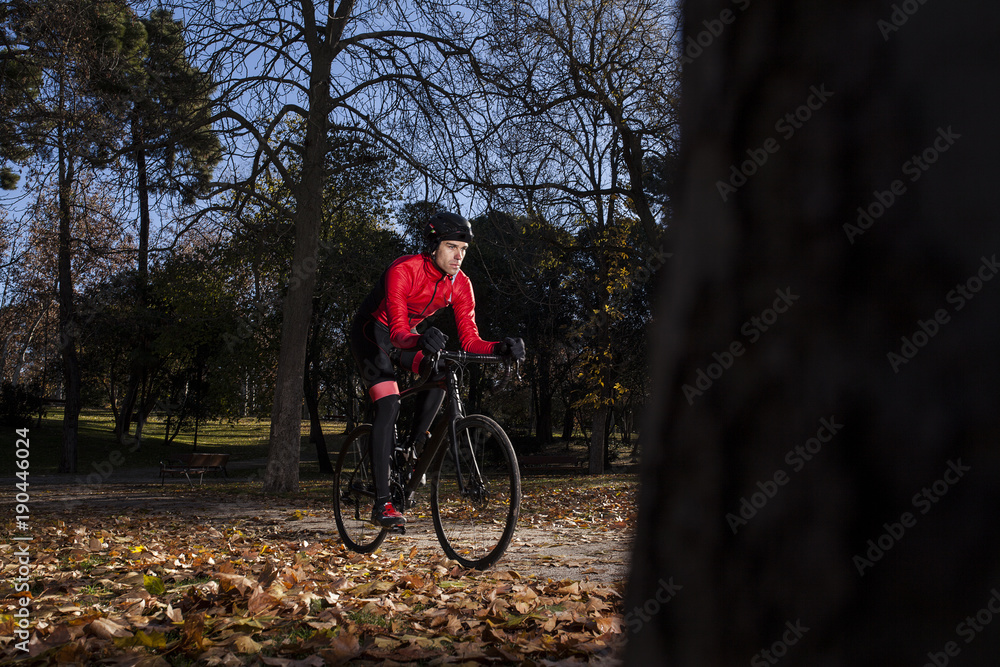 cyclist riding in the park with leaves on the ground in autumn 03 cyclist riding in the park with leaves on the ground in autumn 03
