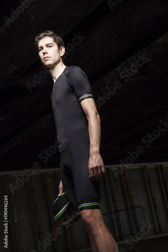 cyclist holding the helmet in the darkness of the tunnel