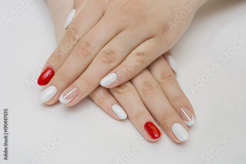 Manicure. White nails with red hearts. Isolated.