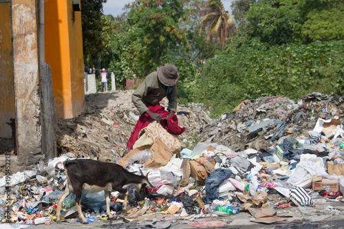 Fotografia man digging thru the trash in third world country