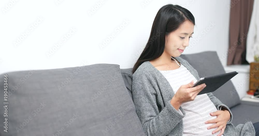 Pregnant woman using tablet computer at home Pregnant woman using tablet computer at home