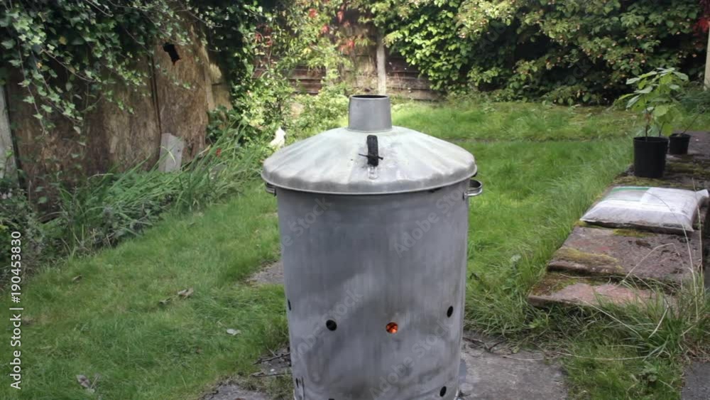 Garden incinerator light smoke and adding more garden waste Garden incinerator light smoke and adding more garden waste