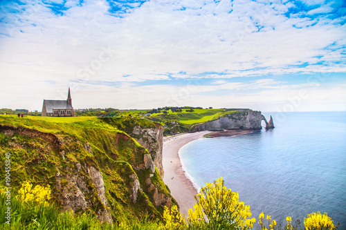 Etretat village, beach and Aval cliff landmark on ocean. Normandy, France.