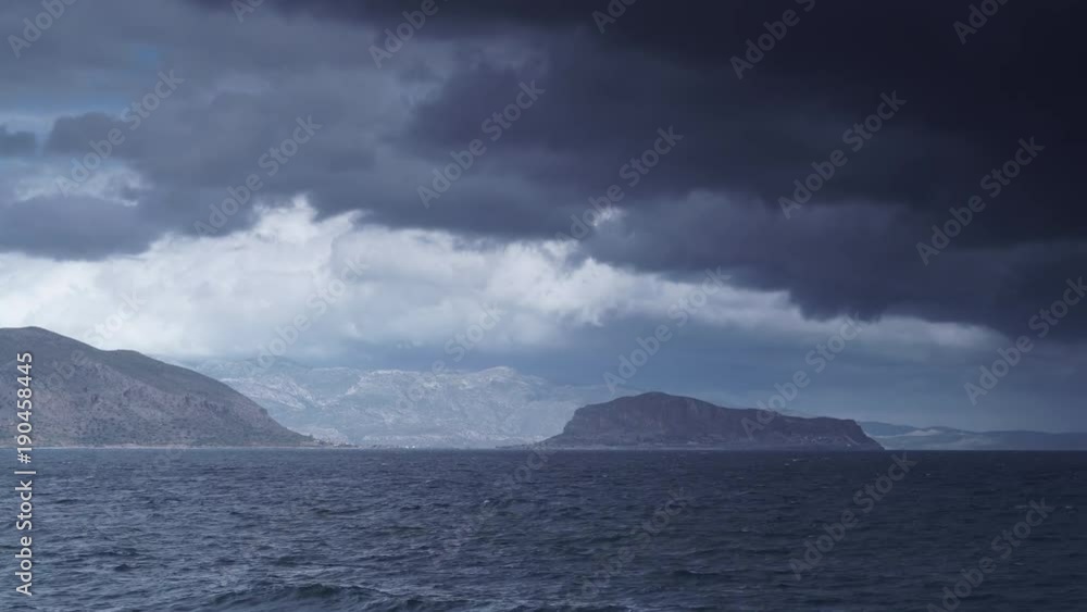 Greek island Monemvasia and overcast sky with stormy rainy clouds, view from distance. Greece Peloponnese Lakonia, Time lapse Greek island Monemvasia and overcast sky with stormy rainy clouds, view from distance. Greece Peloponnese Lakonia, Time lapse