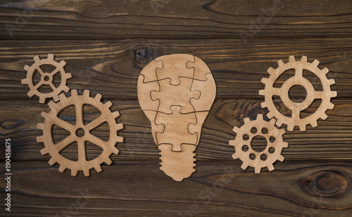 Concept business idea, light bulb and gears on a background of natural wood. Teamwork, strategy. © gerasimov174