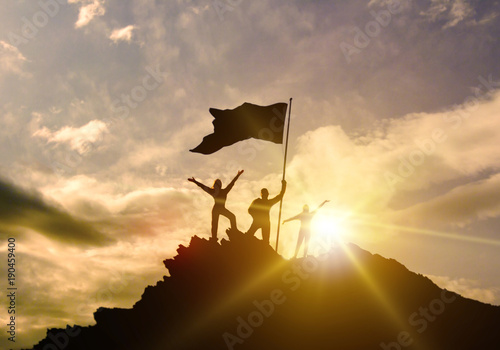 High success, family three silhouette, father of mother and child holding flag of victory on top of mountain, hands up. A man on top of a mountain. Conceptual design. 