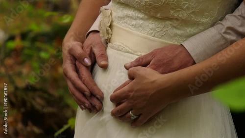 groom has hands around brides waist close up in the forest 4k photo