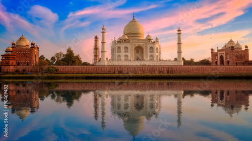 Taj Mahal Agra India at sunset with moody sky and mirror reflections.