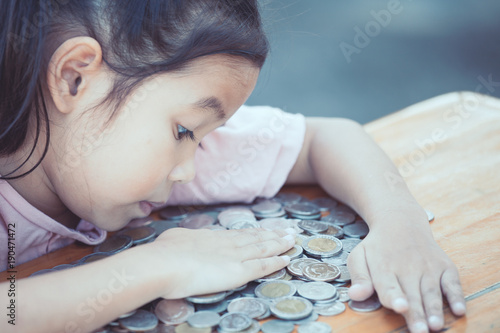 Εκτύπωση καμβά Cute asian little child girl hugging and stingy her money