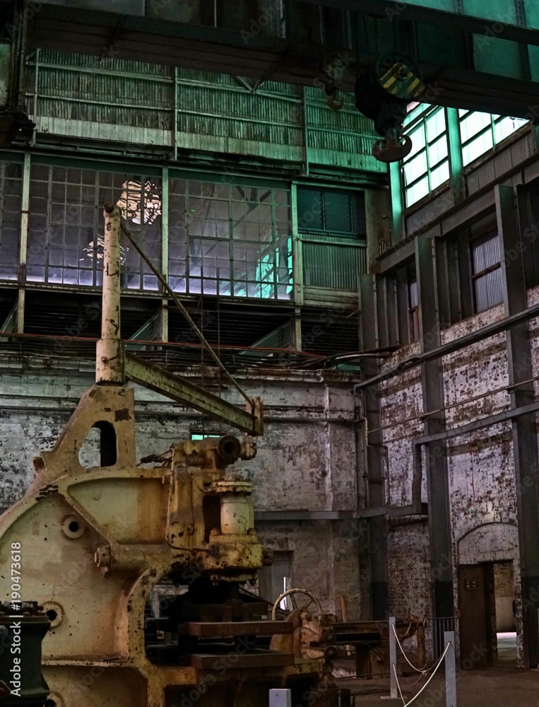 An old machine factory made of steel and used in the past. Broken and rustic machine left over in abandon factory. Image of aged equipment with rust and gear part.