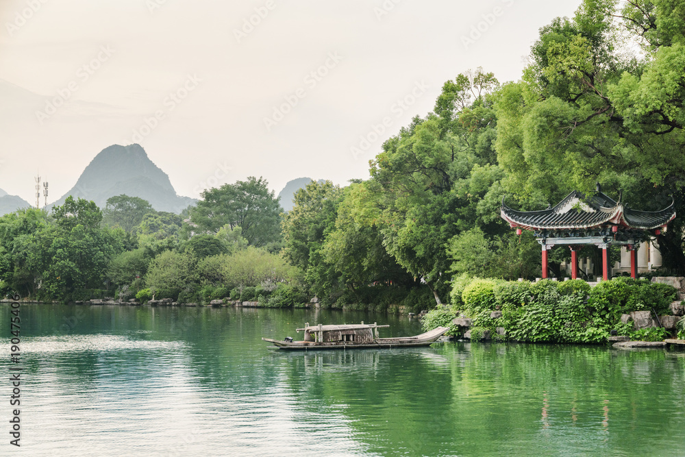 Obraz premium Evening view of traditional Chinese pavilion by lake, Guilin