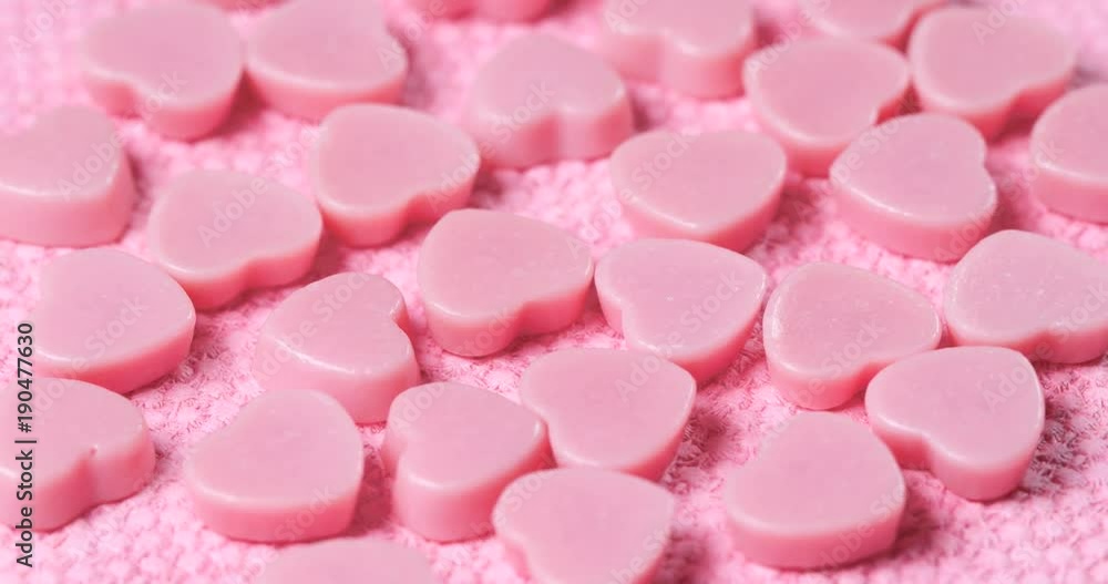 Pink heart shape chocolate candy in rotation Pink heart shape chocolate candy in rotation