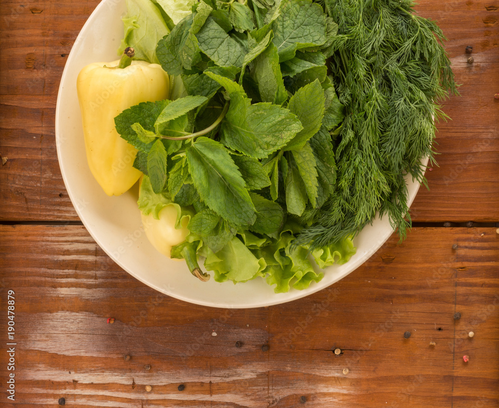 Green pepper with green salad, apple and basil on the plate placed on the rustic vintage wooden background Green pepper with green salad, apple and basil on the plate placed on the rustic vintage wooden background