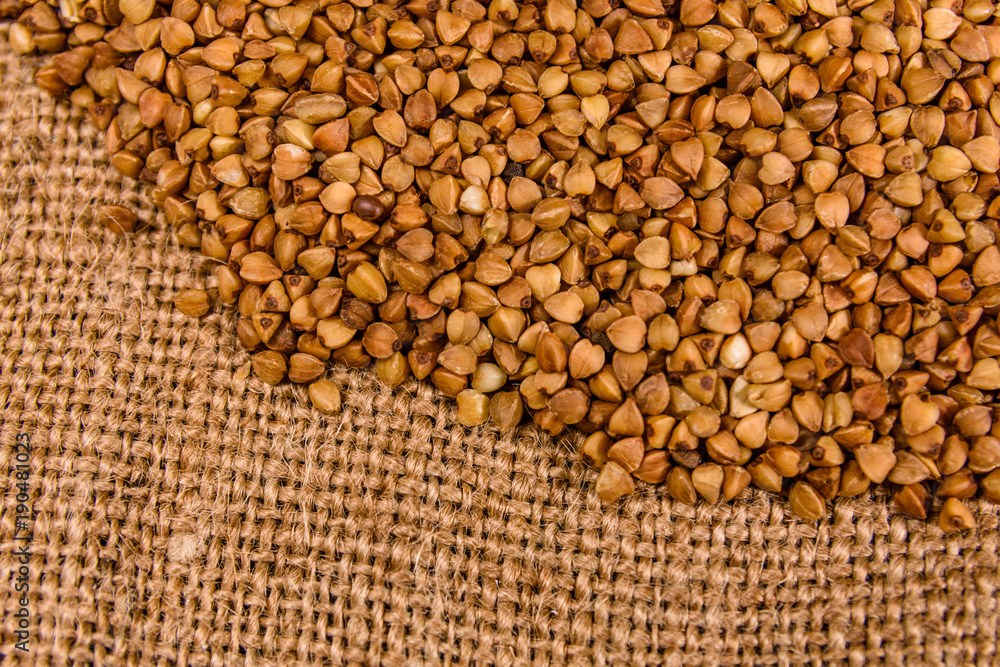 Pile of the raw buckwheat on sackcloth. Top view Pile of the raw buckwheat on sackcloth. Top view