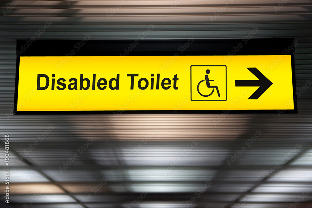 sign with arrow point to disabled toilet at the airport for passenger with impaired body. universal design for elderly or the disabled in public place concept. sign with arrow point to disabled toilet at the airport for passenger with impaired body. universal design for elderly or the disabled in public place concept.