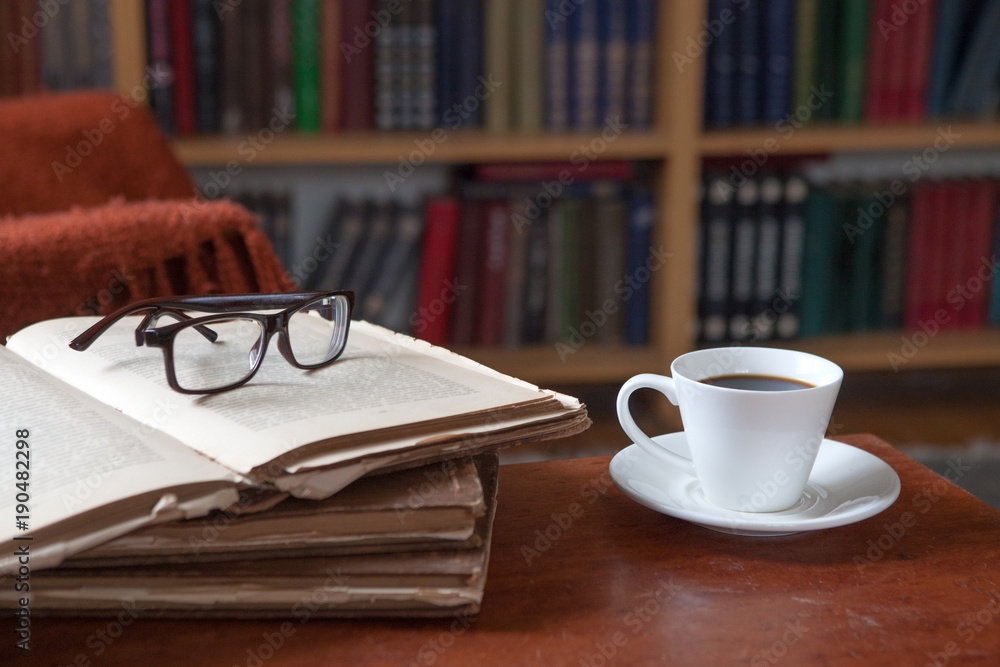 Sweet moments of relaxation with books and a cup of coffee. Vintage books, glasses, chair, library Sweet moments of relaxation with books and a cup of coffee. Vintage books, glasses, chair, library