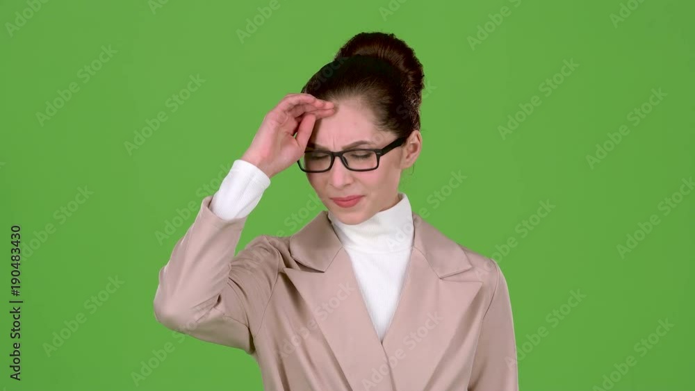 Girl in a business suit is standing in the studio, she has terrible headaches. Green screen Girl in a business suit is standing in the studio, she has terrible headaches. Green screen