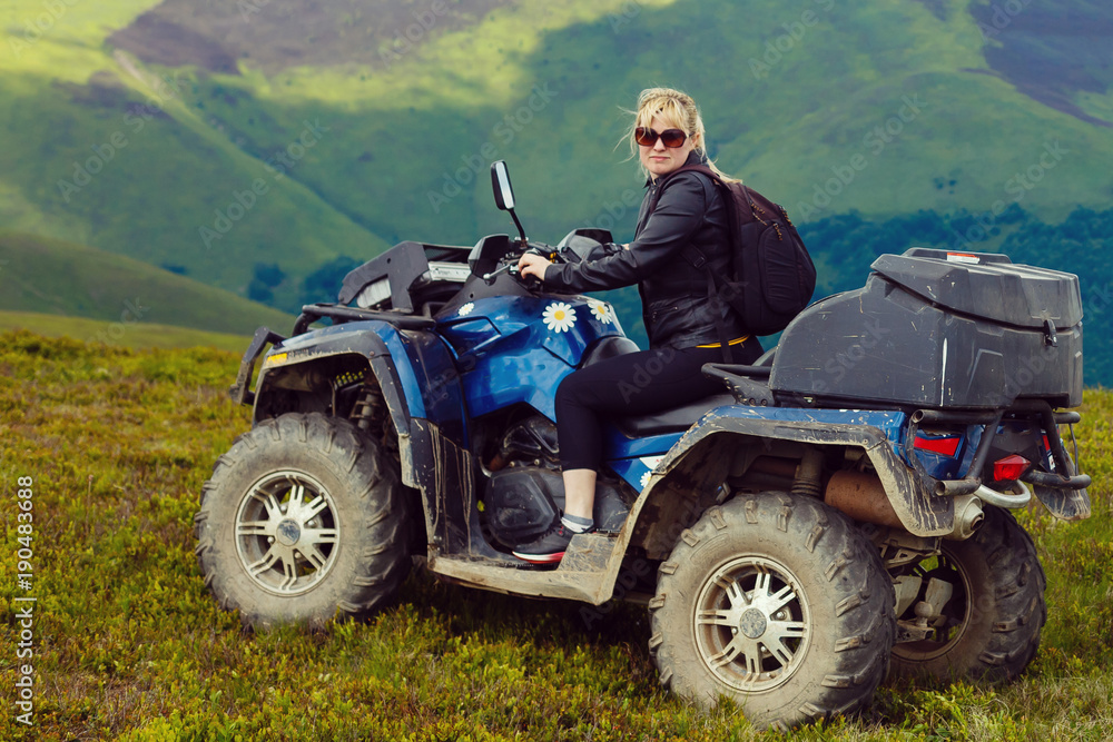 Excited young woman on quad bike. Happy young woman driving all terrain vehicle in nature. Excited young woman on quad bike. Happy young woman driving all terrain vehicle in nature.