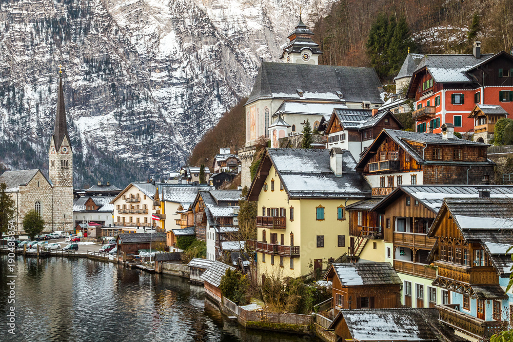 Lake view at the tower and houses of Hallstatt, famous picturesque village in Austria Lake view at the tower and houses of Hallstatt, famous picturesque village in Austria