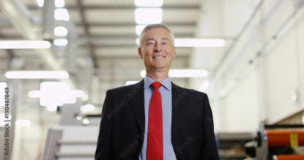 4K Portrait smiling successful businessman in printing factory. Crane shot panning upwards offering interesting change of background. Slow motion. 4K Portrait smiling successful businessman in printing factory. Crane shot panning upwards offering interesting change of background. Slow motion.
