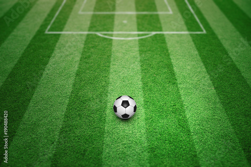 Soccer ball on sunny football field pattern background.