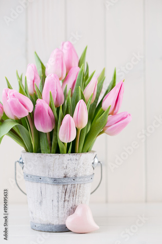 Spring easter tulips in bucket on white vintage background.