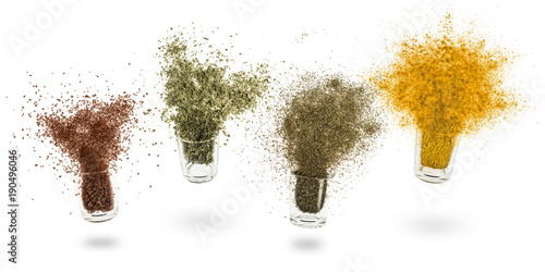 glass jars with various spices flying on white background