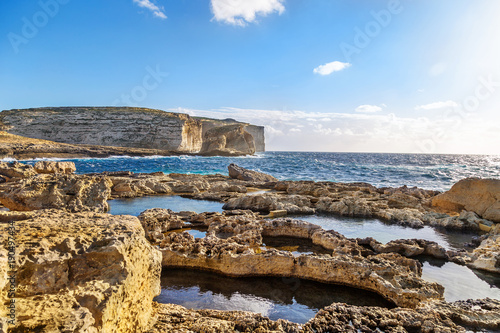 Malta, Gozo Island. Beautiful limestone cliffs facing the ocean near Dwejra Bay with water pools and riffs as seen from the Azure Window.