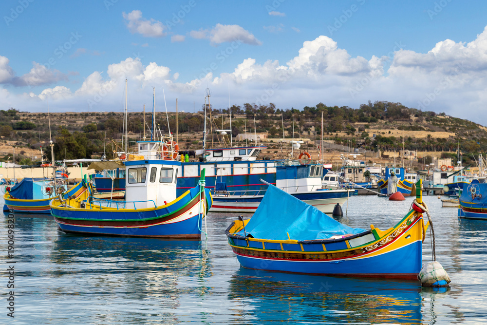 Traditional colourful painted Maltese fishing boats, called luzzu, in the small fishing village Marsaxlokk on Malta.
