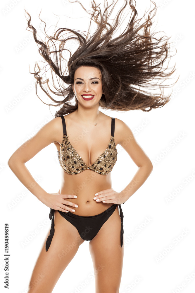 Fototapeta premium Beautiful happy fashion model in black bikini on white background