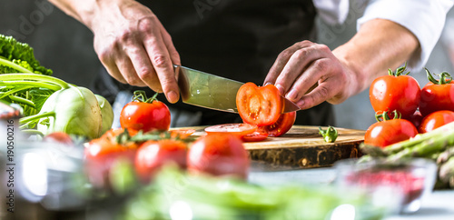 Fototapeta Naklejka Na Ścianę i Meble -  Chefkoch in der Küche mit Frischem Gemüse(Tomaten)