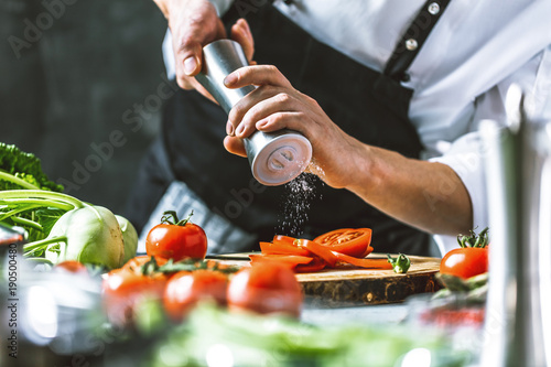Foto Chefkoch in der Küche mit Frischem Gemüse(Tomaten)