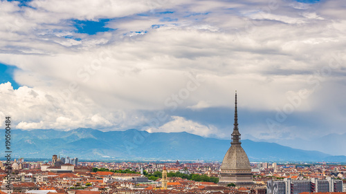 Turin Cityscape, Italy, Torino skyline, the Mole Antonelliana towering over the buildings. Wind storm clouds over the Alps in the background.