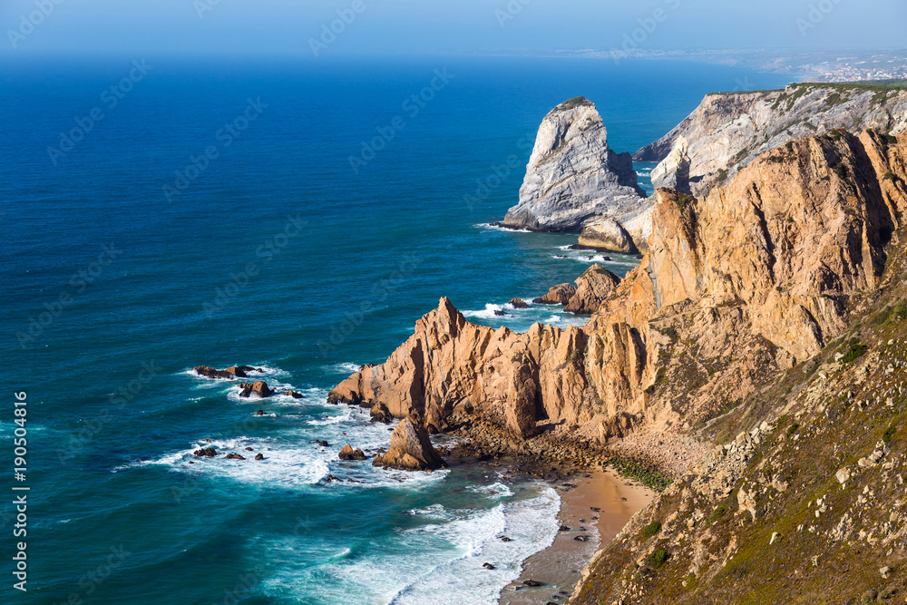 Ocean meets Cliffs of Cabo da Roca (Cape Roca) in Sintra - the westernmost extent of mainland Portugal and Europe. The most western point of Europe. Popular touristic destination and attraction.