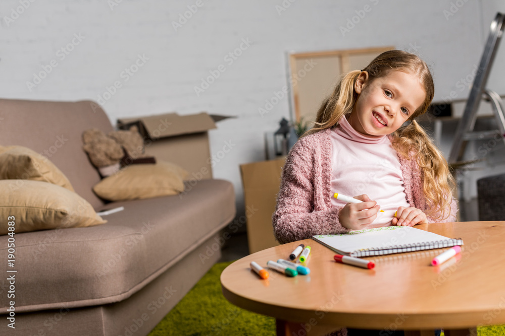 cute little child drawing with felt tip pens and smiling at camera at home cute little child drawing with felt tip pens and smiling at camera at home
