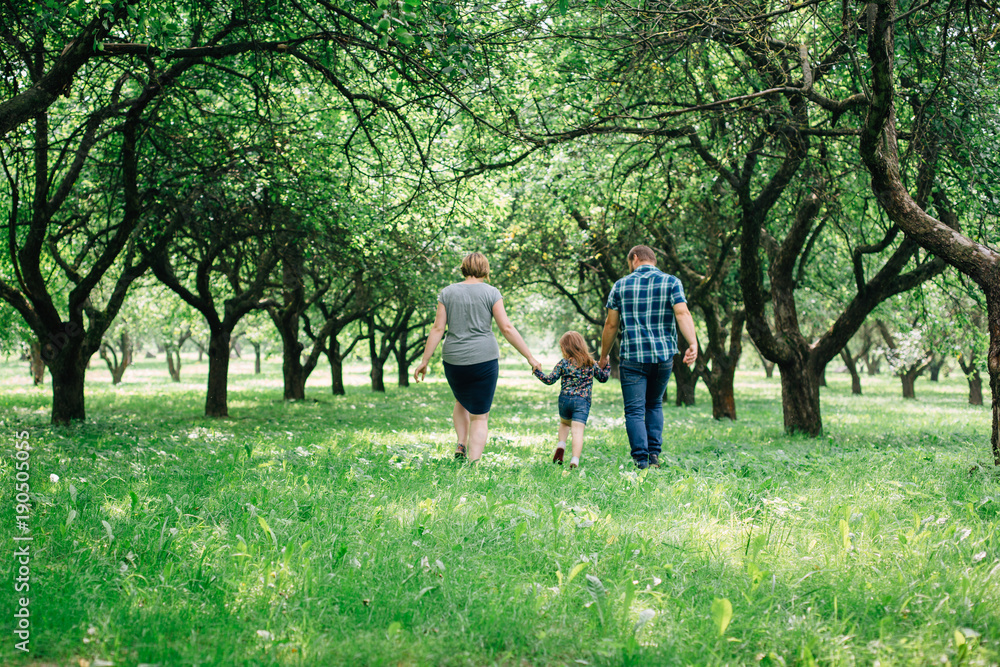Cute young happy family having fun in the park. Little girl with parents outdoors. Mother father and daughter. Cute young happy family having fun in the park. Little girl with parents outdoors. Mother father and daughter.