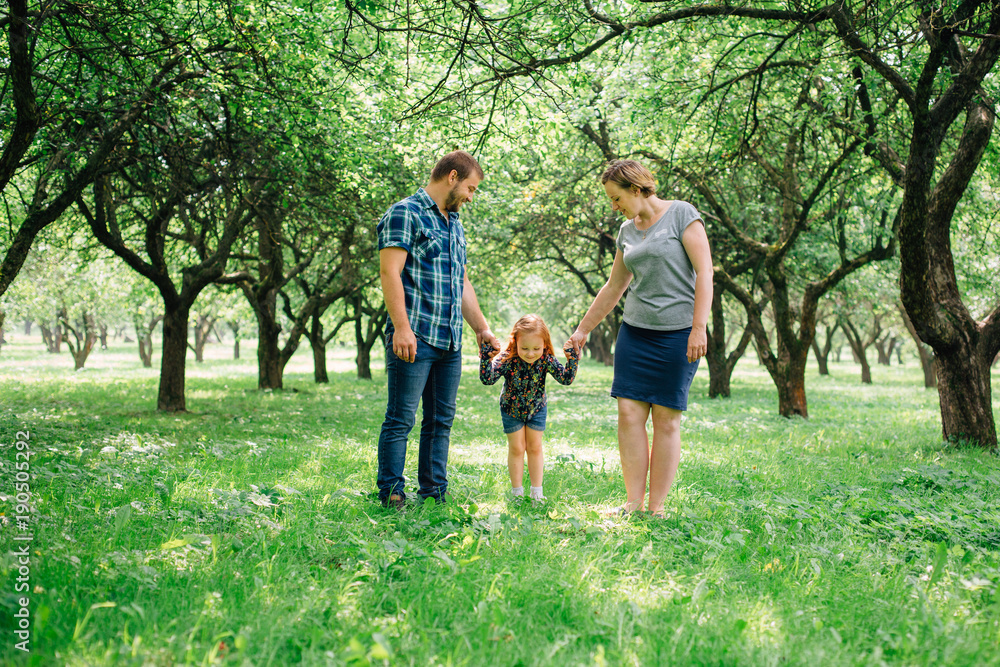 Cute young happy family having fun in the park. Little girl with parents outdoors. Mother father and daughter. Cute young happy family having fun in the park. Little girl with parents outdoors. Mother father and daughter.